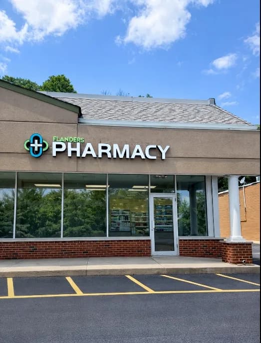 Friendly pharmacist welcoming customers at Flanders Pharmacy